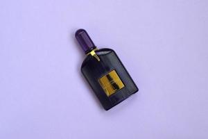 La bouteille de parfum de parfum d'orchidée de velours Tom Ford repose sur un fond lilas clair. tom ford est un créateur de mode américain a lancé sa marque de luxe éponyme en 2006 photo