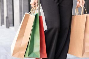 mise au point sélective sur des sacs à provisions colorés. les femmes ramènent de nombreux achats et sortent du grand magasin de mode. vente de fin d'année que le client a acheté à volume élevé. photo