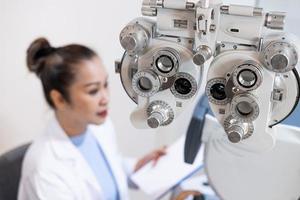 mise au point sélective sur l'équipement de cadre d'optométrie. avec arrière-plan flou tandis que l'optométriste examine le système visuel des yeux des patientes âgées avec une machine professionnelle avant de fabriquer des lunettes. photo