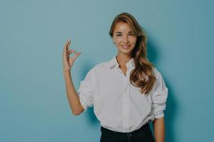 le modèle féminin montre un geste correct vous assure que quelque chose est bon étant confiant dans la qualité photo