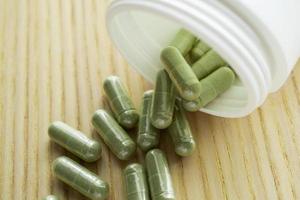 Capsules de phytothérapie avec bouteille sur table en bois photo