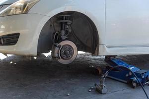 changer un pneu de voiture causé par une crevaison en utilisant un cric pour soulever la voiture. photo
