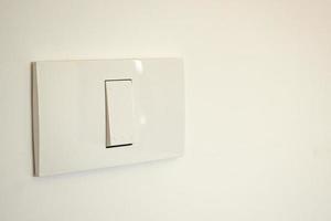 Interrupteur d'éclairage blanc sur mur de béton photo