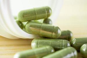 Capsules de phytothérapie avec bouteille sur table en bois photo