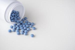 Médicament bleu pilules avec bouteille sur fond blanc photo
