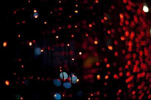 guirlandes rouges sur la fenêtre. lumières dans l'obscurité. lampes rouges. détails intérieurs. photo