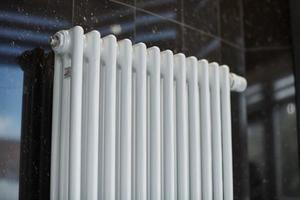 radiateur de chauffage au bureau, gros plan. échangeurs de chaleur blancs. radiateur à vapeur en aluminium de fer. modèle de tuyau. photo