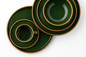un ensemble de vaisselle en céramique vert foncé avec des contours orange sur fond blanc photo