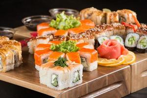 un gros plan d'un ensemble de sushis sur une plaque de bois photo