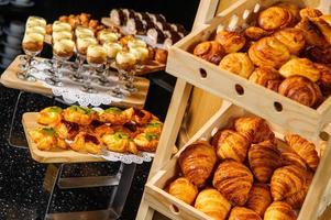 une table de buffet avec des paniers en bois remplis de croissants pour l'exposition de produits photo