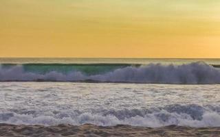 coucher de soleil doré coloré grande vague et plage puerto escondido mexique. photo