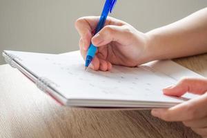 main de femme avec un stylo écrit sur la date du calendrier concept de réunion de rendez-vous de planification d'entreprise photo