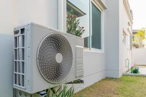 Compresseur d'unité extérieure de climatisation installé à l'extérieur de la maison photo