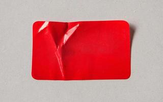Étiquette autocollante en papier rouge sur fond de carton photo
