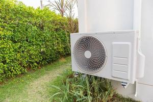 Compresseur d'unité extérieure de climatisation installé à l'extérieur de la maison photo