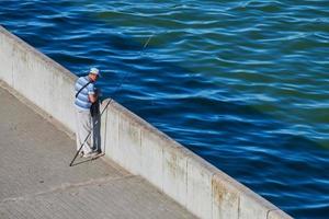 vieux pêcheur au bord de l'eau photo