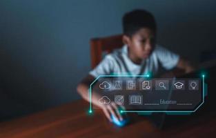 icône de l'éducation sur le fond des images floues un garçon regarde fixement un écran d'ordinateur. concept éducatif, recherche d'informations éducatives, espace de copie photo