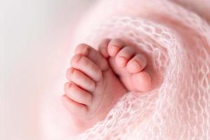 gros plan de pieds nouveau-nés enveloppés dans une couverture tricotée photo