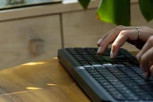 travaillant à la maison avec une femme portable écrivant un blog. mains féminines sur le clavier photo