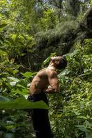 homme vu de près, sans chemise faisant des étirements sur un tapis de yoga, exercice, amérique latine photo