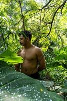 homme vu de près, sans chemise faisant des étirements sur un tapis de yoga, exercice, amérique latine photo