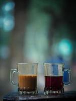 tasses de thé au lait et thé de couleur sur fond de nature de table en bois dans un ton chaud de jardin photo