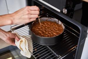 femme au foyer prépare un gâteau dans la cuisine. gâteau maison cuisson au four photo