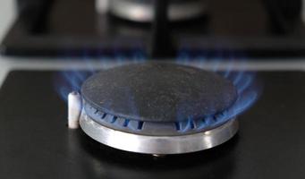 gros plan des flammes bleues du feu sur un brûleur à gaz dans la cuisine pour la cuisson. flamme de gaz dans une chaudière à gaz photo