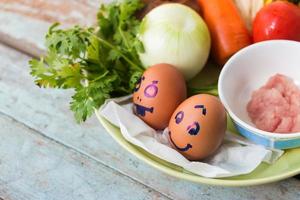 légumes frais, œufs et côtelettes de porc. sur bois bleu photo