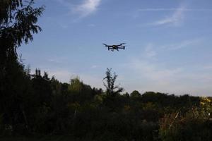 drone dans le ciel. vol de drone au-dessus de la forêt. véhicule aérien. photo