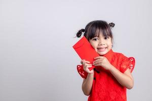 joyeux Nouvel An chinois. petites filles asiatiques souriantes tenant une enveloppe rouge photo