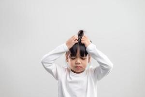 triste petite fille tient sa tête. petite fille se sentant malade, ayant des maux de tête. photo