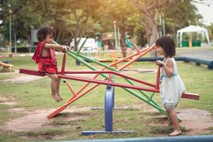 deux petites filles heureuses sur une planche chancelante en plein air photo