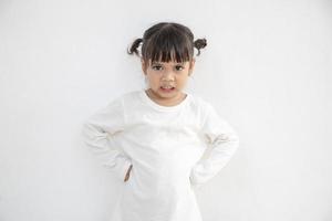 Petite fille en colère sur fond blanc, concept de signe et de geste photo