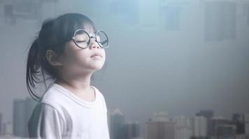 petite fille asiatique fermant les yeux et paysage urbain moderne. photo
