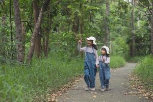 les enfants se dirigent vers le camping familial en forêt à pied le long de la route touristique. route des campings. concept de vacances de voyage en famille. photo