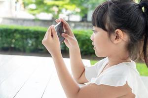 petite fille utilisant un smartphone, concept de médias sociaux. photo