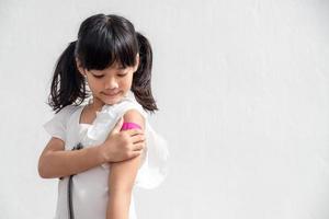 petite fille asiatique montrant son bras après avoir été vaccinée ou vaccinée, vaccination des enfants, concept de vaccin delta covid