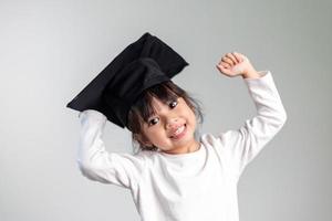 heureux écolier asiatique diplômé en chapeau de graduation photo