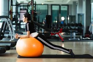 photo de belle jeune femme sportive. fille travaillant avec un ballon de fitness