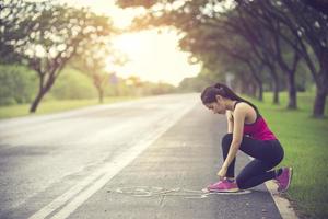 Jeune femme runner attacher ses lacets on country road photo