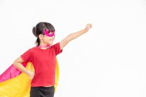 drôle de petite fille jouant au super-héros de puissance sur fond blanc. notion de super-héros. photo