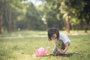 gros plan fille asiatique enfant plantant un arbre dans la nature verte, deux mains tenant et soignant, semis ou arbre poussant dans le sol, journée mondiale de l'environnement, jour de la terre, environnement, écologie photo