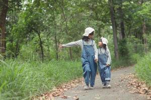 les enfants se dirigent vers le camping familial en forêt à pied le long de la route touristique. route des campings. concept de vacances de voyage en famille. photo