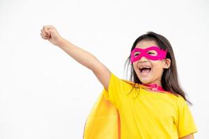 drôle de petite fille jouant au super héros de puissance sur fond blanc. notion de super-héros. photo