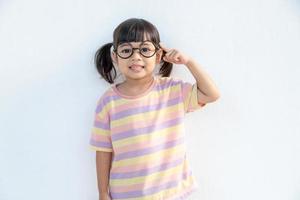 drôle d'enfant asiatique fille portant des lunettes sur fond blanc photo