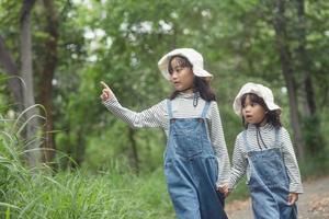 les enfants se dirigent vers le camping familial en forêt à pied le long de la route touristique. route des campings. concept de vacances de voyage en famille. photo