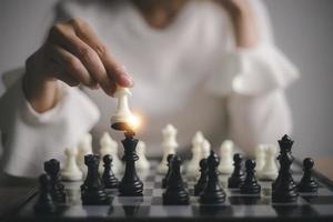 femme d'affaires joue avec le jeu d'échecs. concept de stratégie et tactique d'entreprise. concept de stratégie, de gestion ou de leadership photo