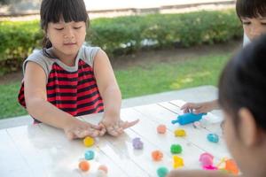 les enfants asiatiques jouent avec des formes de moulage d'argile, apprenant par le jeu photo