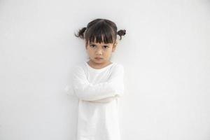 Petite fille en colère sur fond blanc, concept de signe et de geste photo